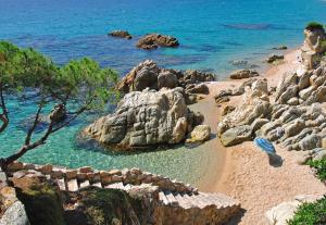 a view of a beach with rocks and the ocean at Kampaoh Platja d'Aro in Platja  d'Aro