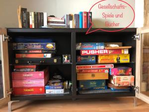 a book shelf filled with lots of books at Studio - grosses Wohn-Schlafzimmer - Dachterrasse - Kamin - Küche - Hohes Venn - Monschau - Eifel - Hunde willkommen beim Hof Vierzehnender in Monschau