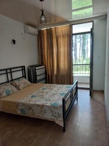 a bedroom with a bed and a large window at Sommer by Sveta / Лето у Светы in Ureki