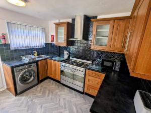 cocina con fogones y lavavajillas en No 51 - Spacious 3 Bed Home - Free Parking - Wi-Fi - Contractors, en West Derby