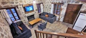 een woonkamer met banken en een televisie bij Authentic Bodrum Villa with Special Private Pool in Ortakent