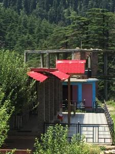 un bâtiment avec des parasols rouges en face d'une maison dans l'établissement Abhi Homestay- Homestay In, à Khajjiar 
