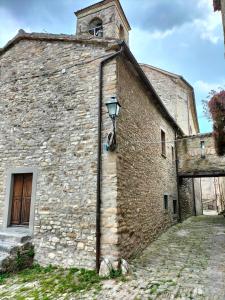 an old stone building with a street light on it at Casa in Borgo Medievale in Toscana in Monterone