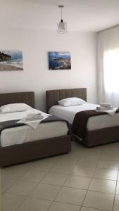 a bedroom with two beds and a window at Lion's Apartments Vlora in Vlorë
