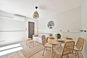- un salon avec une table, des chaises et un canapé dans l'établissement L'Olivier - 2 terrasses - Clim AC - WIFI - PROCHE THEATRES, à Avignon
