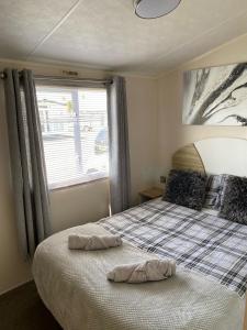 um quarto com uma cama com duas almofadas em P&T's everything a family needs including decking private WIFI and Smart TV em Rhyl