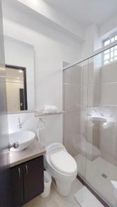 biała łazienka z toaletą i umywalką w obiekcie Hotel MS Pacifico Chipichape w mieście Cali