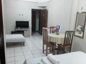 sala de estar con mesa, sillas y TV en NEW BUSINESS en Macapá