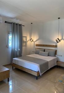 a bedroom with a large white bed with two lights at Primos Del Mar Kalamitsi in Kalamitsi