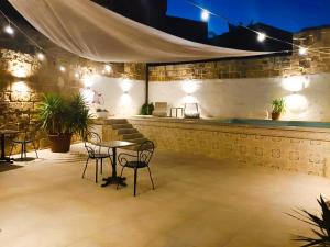 a patio with a table and chairs at night at Lemon Tree Relais by CX Collection in Żabbar