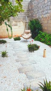 un jardin avec une balançoire et une passerelle en pierre dans l'établissement Lemon Tree Relais by CX Collection, à Żabbar
