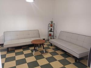 twee witte banken en een tafel in een kamer bij hébergement de la plage en ville in Martigues