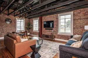 a living room with two couches and a brick wall at The Loft at 113 - Gateway to the North Texas Hill Country in Muenster