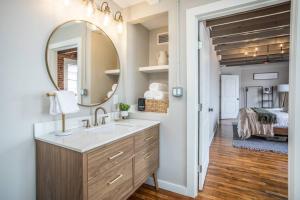 The Loft at 113 - Gateway to the North Texas Hill Country في Muenster: حمام مع حوض ومرآة وغرفة نوم +18 صورة