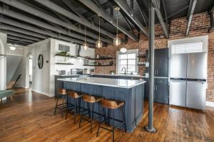 a kitchen with a blue island with bar stools at The Loft at 113 - Gateway to the North Texas Hill Country in Muenster