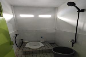 La petite salle de bains est pourvue d'une douche et de toilettes. dans l'établissement SPOT ON 92599 Pondok Anggrek Syariah, à Pekanbaru
