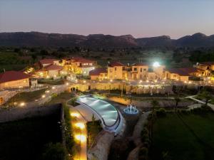 a resort with a swimming pool at night at AamaGhati Wildlife Resort, Ranthambore in Sawāi Mādhopur