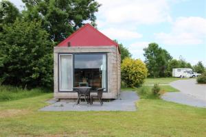a tiny house with a table and a red roof at Tiny Cottage 2 in Drijber
