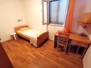 una camera con letto, scrivania e tavolo di Apartment Tonka a Mlini