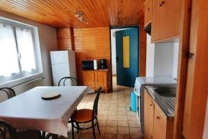 a small kitchen with a table and a table and chairs at plain-pied proche base de loisirs et voie verte in Saulxures-sur-Moselotte
