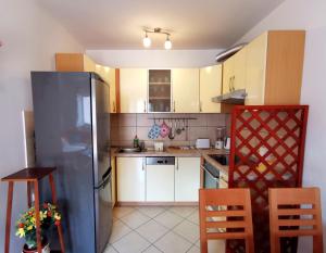 una cucina con frigorifero, tavolo e sedie di Apartment Tonka a Mlini