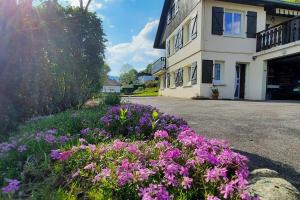 a bunch of purple flowers in front of a building at plain-pied proche base de loisirs et voie verte in Saulxures-sur-Moselotte