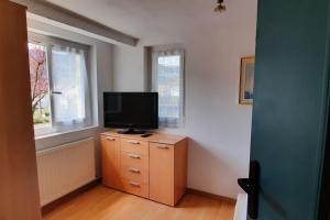a living room with a television on a dresser in a room at plain-pied proche base de loisirs et voie verte in Saulxures-sur-Moselotte