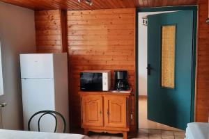 a kitchen with a refrigerator and a microwave at plain-pied proche base de loisirs et voie verte in Saulxures-sur-Moselotte