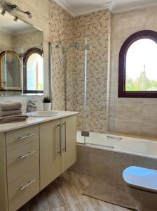 y baño con bañera, lavamanos y ducha. en Villa Octopus by Bebreeze, en Muro