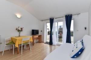 Schlafzimmer mit einem Bett, einem Tisch und einem Schreibtisch in der Unterkunft Apartmani Melia in Zadar