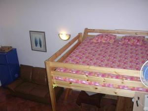 ローマにあるVacanze al Colosseo Polverieraのベッドルーム(木製ベッド1台、ソファ付)
