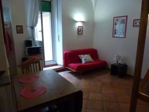 ローマにあるVacanze al Colosseo Polverieraのリビングルーム(赤いソファ、テーブル付)