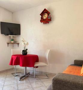 een kamer met een tafel en een klok aan de muur bij Apartments Petrovic in Rogoznica