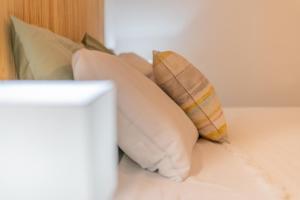 un montón de almohadas encima de una cama en Vivenda Aromas do Algarve, en Monte Raposo