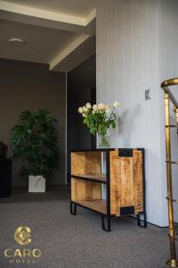 une table avec un vase de fleurs au-dessus dans l'établissement Hotel CARO, à Poznań