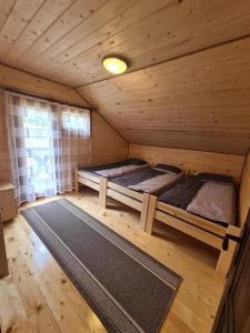 Habitación con 2 camas en una cabaña de madera en Cabana Niki-Rum Haz en Bucin
