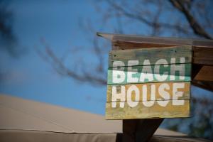 ein Schild, das ein Strandhaus liest in der Unterkunft Glamping at Back Of Beyond Touring Park in Saint Leonards