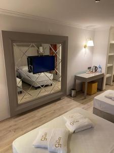 um quarto com duas camas e uma televisão num espelho em FİFTY5 SUİTE HOTEL em Marmaris