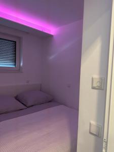 a room with a bed with a pink light at myhouse.5 in Eppelheim