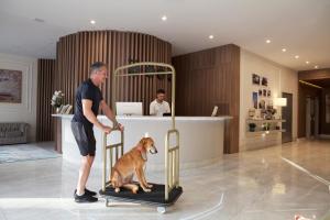mężczyzna stojący obok psa w klatce w obiekcie Lefel Hotel w mieście São Bento do Sul