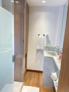 a bathroom with a glass shower and a sink at Hotel Espadarte in Iriri