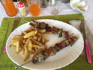 une assiette de nourriture avec des frites et de la viande dans l'établissement Le Rocher, sur l'île Sainte-Marie