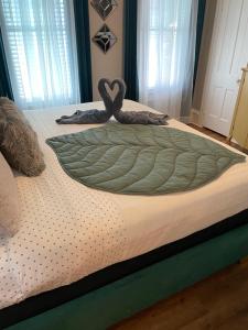 Una cama con una manta verde encima. en Peace & Plenty Inn Bed and Breakfast Downtown St Augustine-Adults Only, en St. Augustine