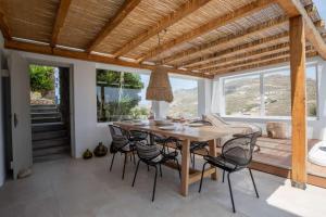 a dining room with a wooden table and chairs at Levantes House Mykonos in Ano Mera