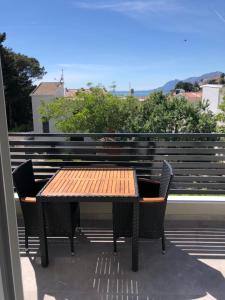 a wooden table and two chairs on a patio at Villa Franko Baška Voda in Baška Voda