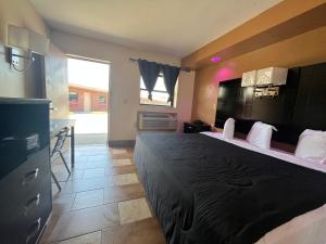 a bedroom with a large bed and a kitchen at Circle Motor Lodge in South Amboy