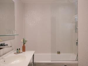 a bathroom with a white tub and a sink at Legend Hôtel Paris in Paris