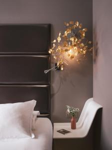 una camera con letto e tavolo con lampada di Legend Hôtel Paris a Parigi
