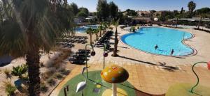 een uitzicht over een zwembad in een resort bij camping sable du midi 4 etoiles in Valras-Plage