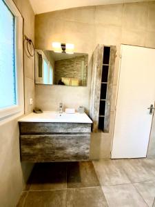 bagno con lavandino e specchio di BAOBAMBOU à 5 min de l'Océan a Vielle-Saint-Girons